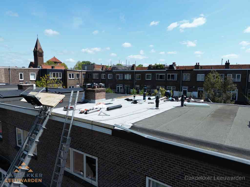 Dakdekkers aan het werk op plat dak in Leeuwarden